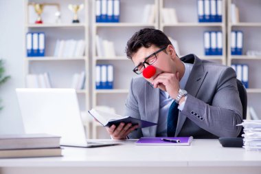 Ofiste çalışan palyaço işadamı.