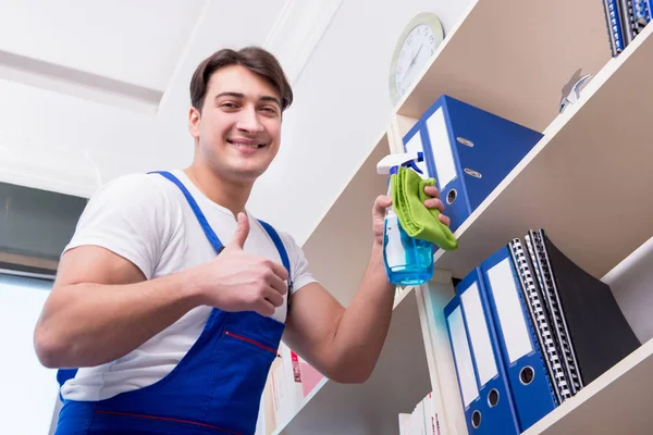 Male office cleaner cleaning shelves in office — Stock Photo, Image