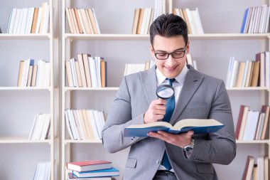 Büyüteçle hukuk fakültesi öğrencisi kitap okuyor.