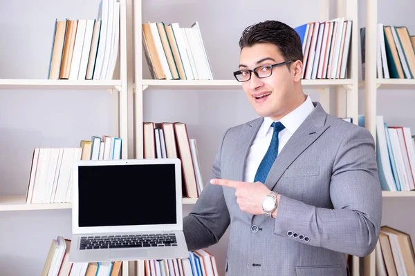 Бизнесмен с пустым экраном ноутбуком, работающий в библиотеке — стоковое фото