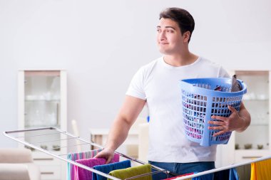 Adam evde çamaşır yıkıyor.