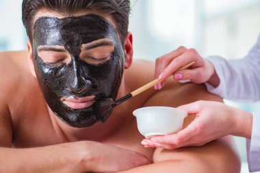 Kaplıca masaj konseptinde yakışıklı bir adam.