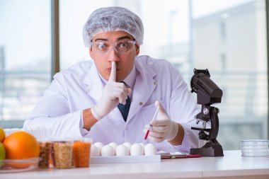 Besin uzmanı gıda ürünlerini laboratuarda test ediyor.