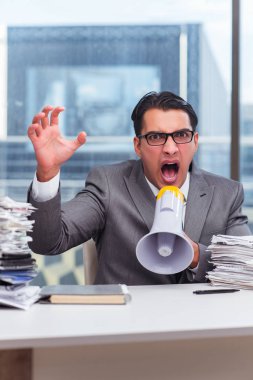 Ofisinde hoparlörü olan kızgın bir işadamı.