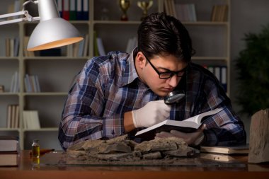 Arkeolog geç saatlere kadar ofiste çalışıyor.