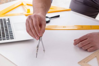 Erkek mühendis çizimler ve planlar üzerinde çalışıyor.