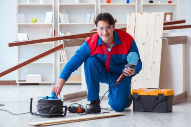 Genç marangoz ahşap kalaslarla çalışıyor.