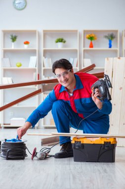 Genç marangoz ahşap kalaslarla çalışıyor.