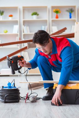 Genç marangoz ahşap kalaslarla çalışıyor.