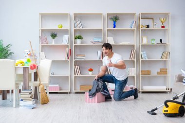 Adam evi temizliyor.