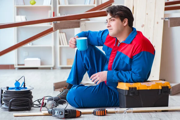 Jovem carpinteiro fazendo uma pausa do trabalho com pranchas de madeira — Fotografia de Stock