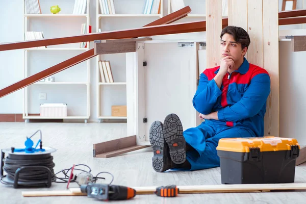 Genç marangoz ahşap kalaslarla çalışmaya ara veriyor.