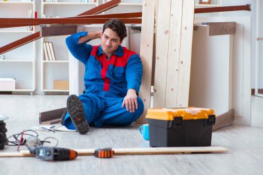 İnşaatta defter planlama yapan genç bir marangoz.