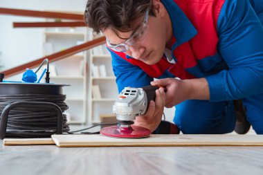 Genç marangoz ahşap kalaslarla çalışıyor.