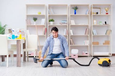 Adam evi temizliyor.