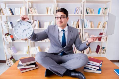 Nilüfer pozisyonunda bir iş adamı ve çalar saati var.