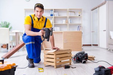 Tamirci marangoz bir seçimle tahta tahtayı kesiyor.