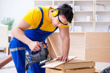 Tamirci marangoz bir seçimle tahta tahtayı kesiyor.