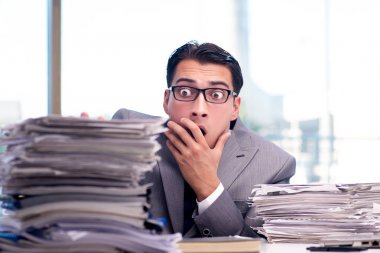 Bir yığın kağıt ile meşgul bir işadamı.