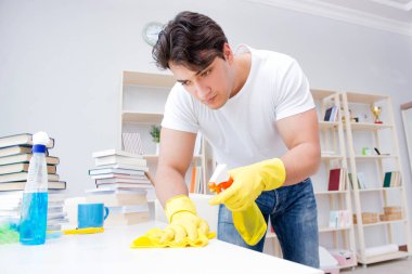 Adam evi temizliyor.