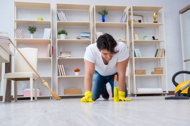 Adam evi temizliyor.