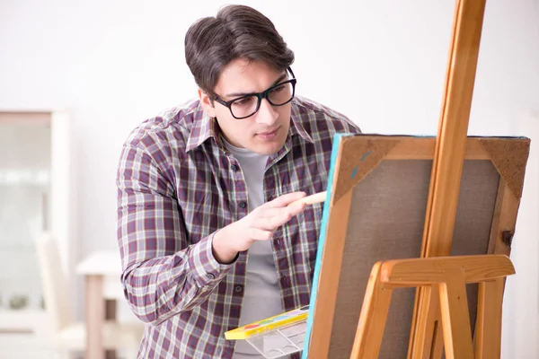 Joven artista masculino dibujando imágenes en estudio brillante — Foto de Stock