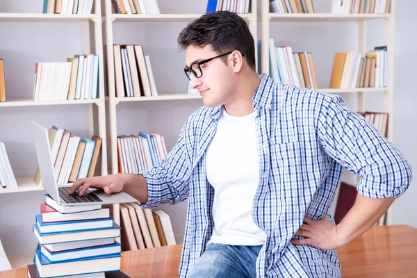 Jonge student met boeken die zich voorbereiden op examens — Stockfoto