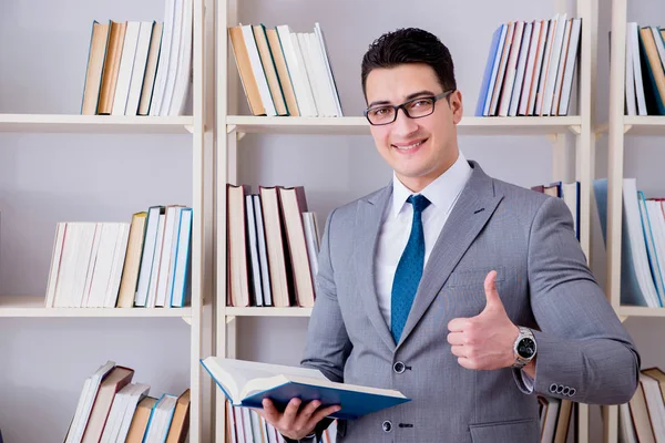 Zakenman student die een boek leest dat in de bibliotheek studeert — Stockfoto