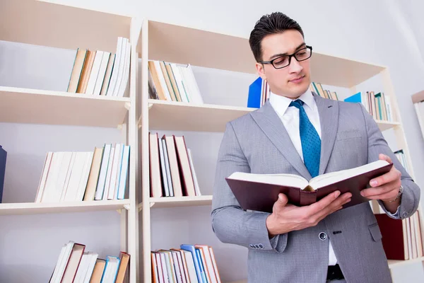 Zakenman student die een boek leest dat in de bibliotheek studeert — Stockfoto