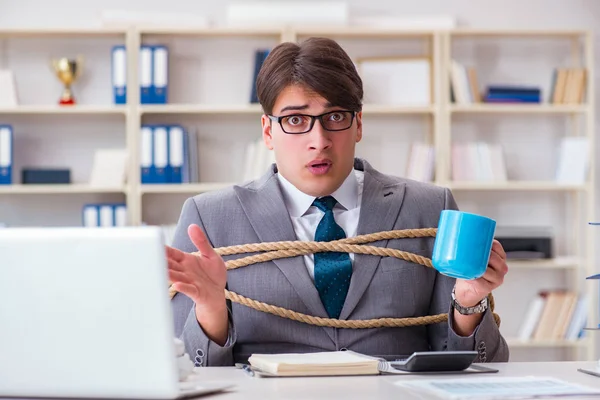 Businessman tied up with rope in office — Stock Photo, Image