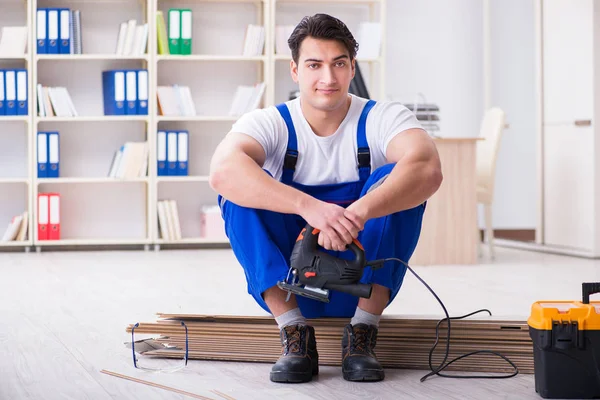 Zemin kaplamalarında çalışan genç bir işçi.