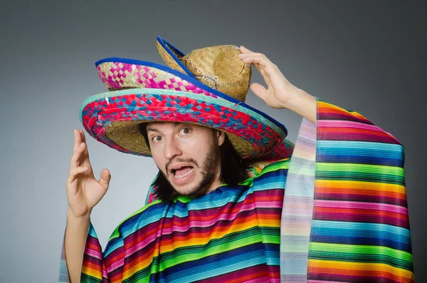 Man in een levendige Mexicaanse poncho grijze achtergrond geïsoleerd — Stockfoto