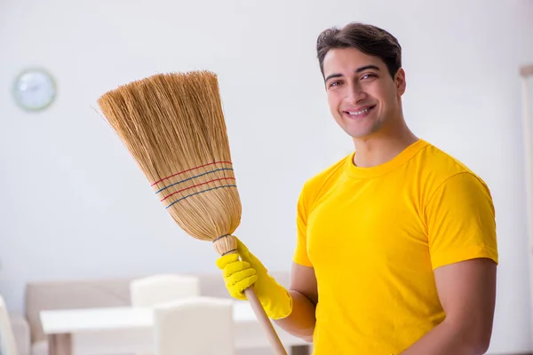 Jeune homme faisant des tâches ménagères à la maison — Photo