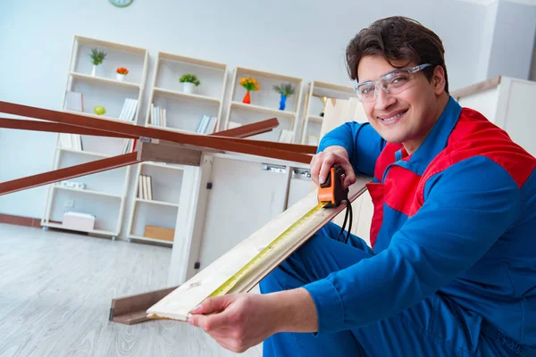 Genç marangoz ahşap kalaslarla çalışıyor.