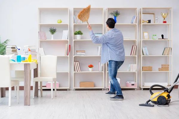 Adam evi temizliyor.