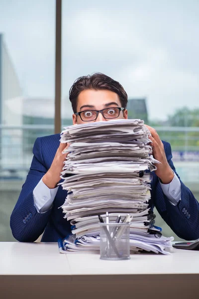 Zakenman met stapel stapel papier papierwerk op kantoor — Stockfoto