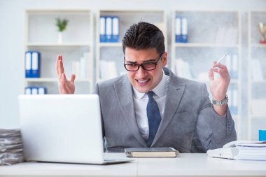 İşadamı ofisinde sigara içiyor.