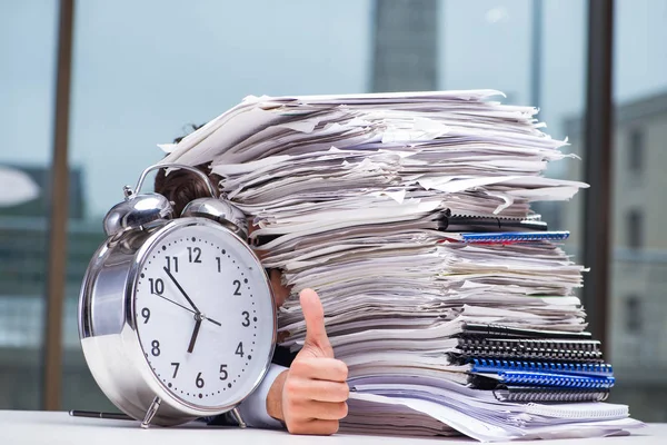 Businessman with pile stack of paper paperwork and an alarm cloc — Stock Photo, Image