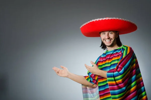 Uomo in un vivido poncho messicano sfondo grigio isolato — Foto Stock