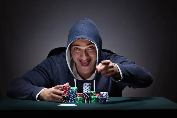 Młody człowiek w kapturze z kartami i żetonami hazard — Zdjęcie stockowe