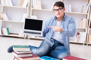 Genç öğrenci kitaplarla çalışıyor.