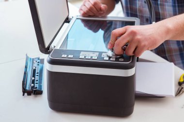 Tamirci bozuk renk yazıcısını tamir ediyor