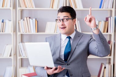 Kütüphanede çalışan bilgisayarlı bir iş adamı.