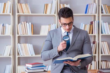 Büyüteçle hukuk fakültesi öğrencisi kitap okuyor.