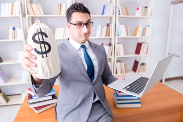 Affärsman i biblioteket med en pengasäck och en laptop — Stockfoto