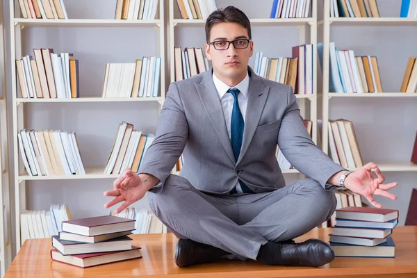 Businessman student in lotus position concentrating  in the libr — Stock Photo, Image