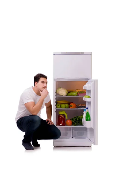 Homem ao lado do frigorífico cheio de comida — Fotografia de Stock