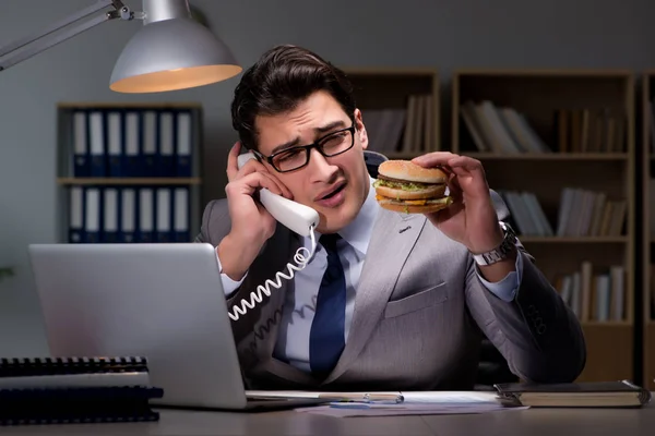 Empresario tarde en la noche comiendo una hamburguesa — Foto de Stock