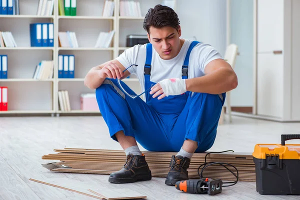 Junge Arbeiter arbeiten an Laminatfliesen — Stockfoto