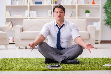 İş adamı ofiste yerde oturuyor.